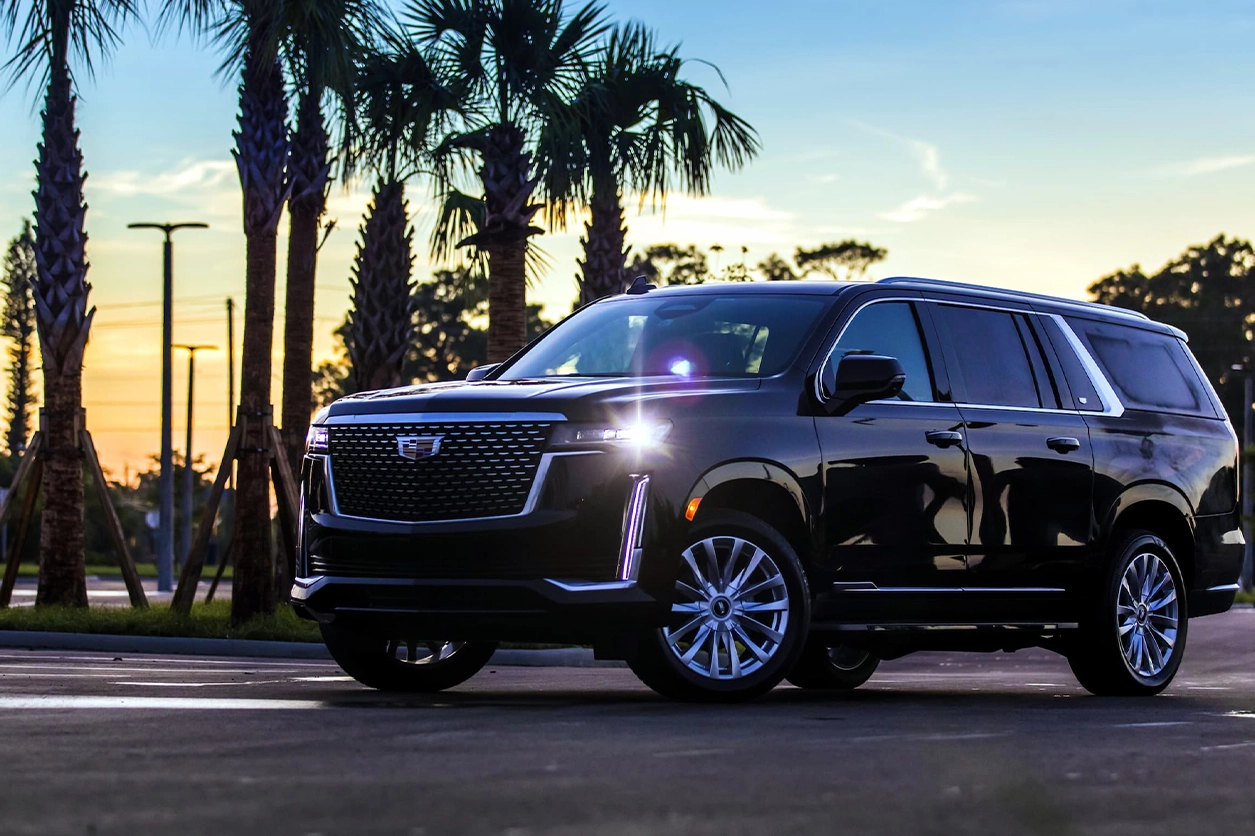 Luxury SUV parked at sunset with palm trees in the background