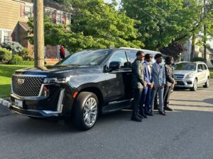 Group of friends posing next to a Cadillac Escalade, ready for their prom night with luxury limo service from Noor Limousine LLC.