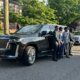 Group of friends posing next to a Cadillac Escalade, ready for their prom night with luxury limo service from Noor Limousine LLC.