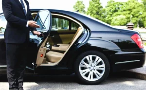 Chauffeur opening the door of a luxurious vehicle for a client, offering Newark Airport limo services.