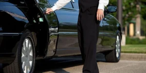 Professional chauffeur opening the door of a luxury vehicle, offering a premium transportation experience.