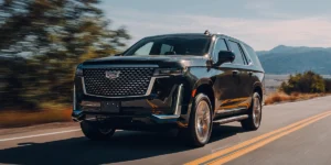 Luxury Cadillac Escalade driving on the road, available for rent with Noor Limousine LLC for premium transportation.