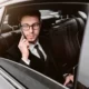 Passenger talking on the phone in the back seat of a black car service vehicle